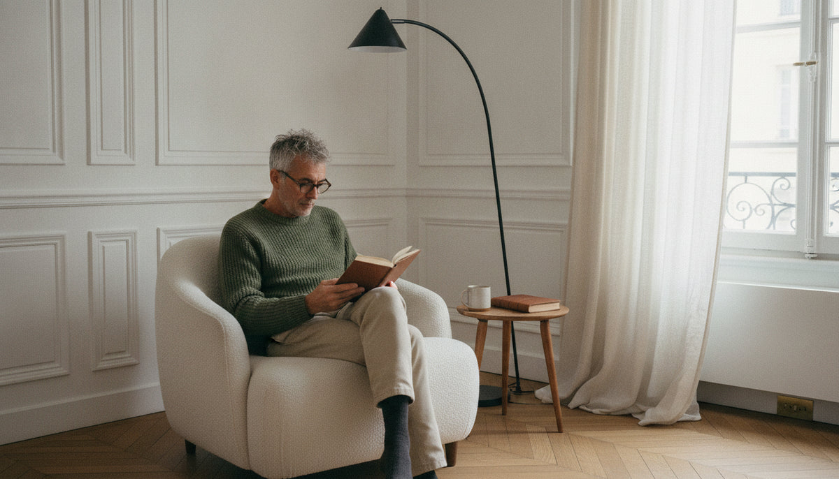 Arched floor lamp curving over a reading chair in a Parisian-style living room