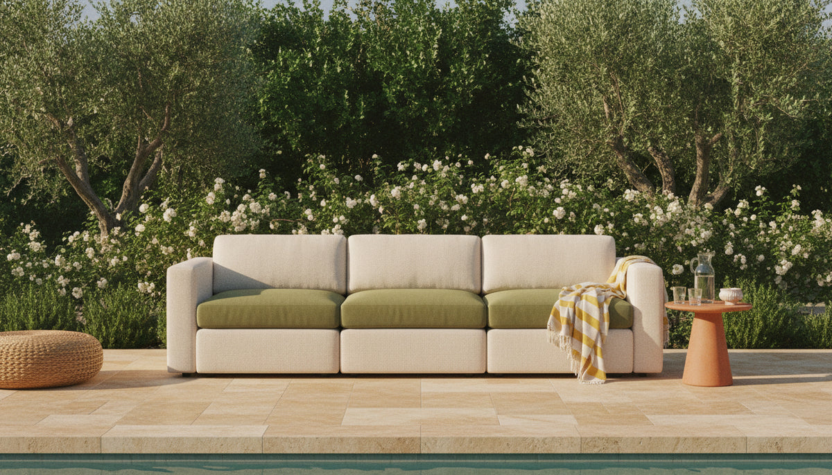 Cream outdoor lounge sofa with olive-green cushions on a travertine pool terrace
